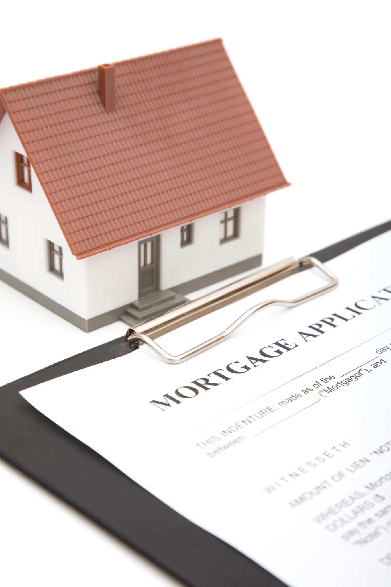 Model house placed on a mortgage application form representing home loan process